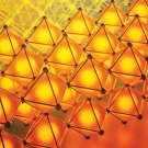 Rows of bright orange tetrahedral shapes against a red/yellow background. 